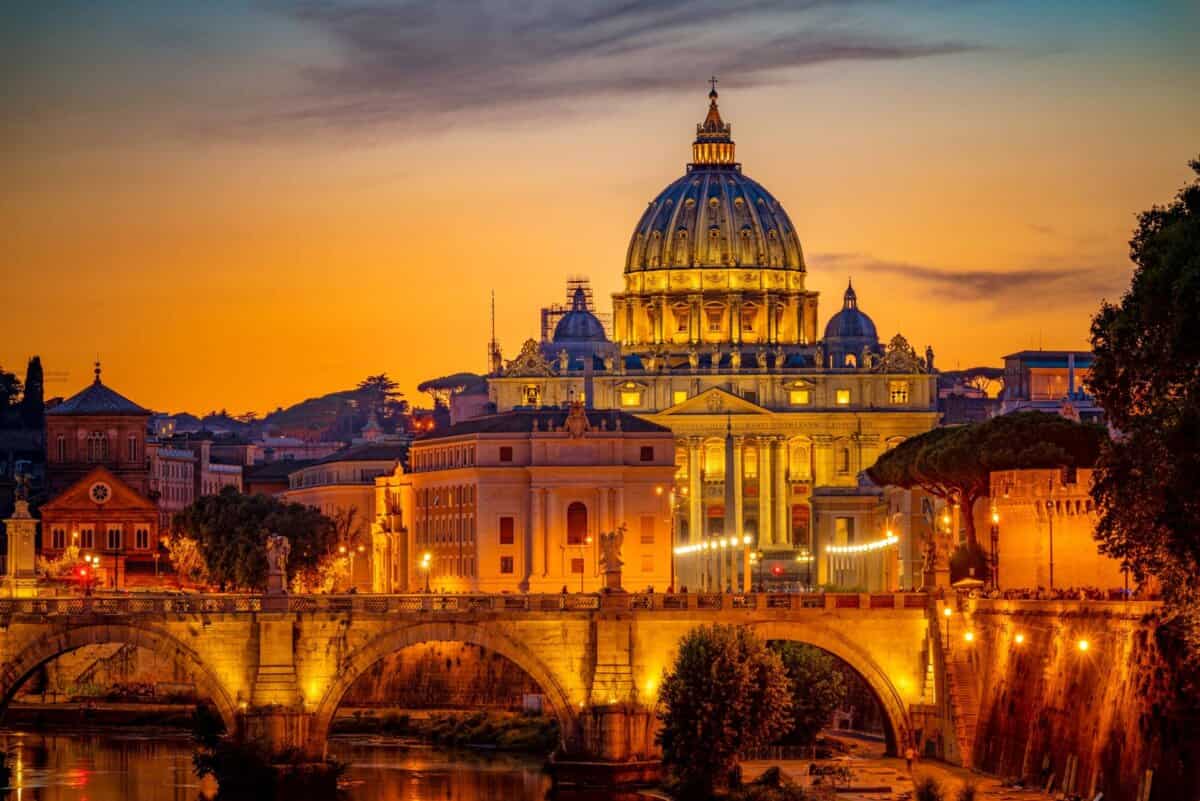 Vista de la puesta de sol de la Ciudad del Vaticano con San Pedro iluminado.